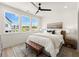Bright bedroom featuring a ceiling fan, area rug, and a large window offering outside views at 654 Soul Aly # 102, Alpharetta, GA 30009