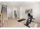 Exercise room with hardwood floors has a stationary bike, yoga mat, stairs to the upper level, and bathroom access at 654 Soul Aly # 102, Alpharetta, GA 30009