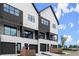 Modern townhomes featuring black framed windows, balconies, and garages at 654 Soul Aly # 102, Alpharetta, GA 30009