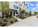 Townhome exterior featuring black framed windows, freshly landscaped yards, and concrete sidewalks at 654 Soul Aly # 102, Alpharetta, GA 30009