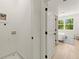 Hallway that leads to a bedroom and includes a utility sink and washing machine connections at 654 Soul Aly # 102, Alpharetta, GA 30009
