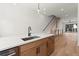 Open concept kitchen with island, wood cabinets, white countertop, and adjacent staircase at 654 Soul Aly # 102, Alpharetta, GA 30009