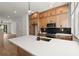Modern kitchen boasting a large island, wood cabinets, and stainless steel appliances at 654 Soul Aly # 102, Alpharetta, GA 30009