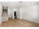 Open-concept living area with hardwood floors, staircase, white walls and a bathroom on the first floor at 654 Soul Aly # 102, Alpharetta, GA 30009
