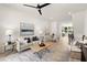Spacious living area featuring hardwood floors, comfortable seating, a ceiling fan, and open access to the dining area at 654 Soul Aly # 102, Alpharetta, GA 30009
