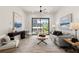 The well-lit living area includes hardwood floors, comfortable seating, a large window with neighborhood views, and modern artwork at 654 Soul Aly # 102, Alpharetta, GA 30009