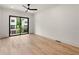 Spacious main bedroom with hardwood flooring, white walls, and sliding glass doors to a private balcony at 654 Soul Aly # 102, Alpharetta, GA 30009