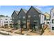 View of new construction townhomes with dark brick, modern design, and manicured landscaping at 654 Soul Aly # 102, Alpharetta, GA 30009