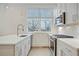 Sleek kitchen featuring white cabinets, stainless steel appliances, and natural light at 654 Soul Aly # 102, Alpharetta, GA 30009
