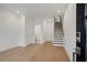 Inviting living space featuring pristine white walls, hardwood floors, and staircase at 654 Soul Aly # 102, Alpharetta, GA 30009
