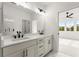 Bright bathroom features a dual sink vanity and an adjacent room with a large window at 673 Soul Aly # 146, Alpharetta, GA 30009