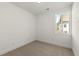 Small bedroom features neutral walls and carpet, a window, and white baseboards at 673 Soul Aly # 146, Alpharetta, GA 30009