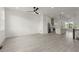 Open living room, featuring kitchen, staircase with black railing, large windows, and light floors at 673 Soul Aly # 146, Alpharetta, GA 30009