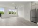 Open-concept living space with light wood floors, large windows, and a stainless steel refrigerator at 673 Soul Aly # 146, Alpharetta, GA 30009