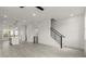 Bright living room with a staircase featuring a metal railing and an open doorway at 673 Soul Aly # 146, Alpharetta, GA 30009