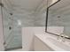 Modern bathroom features a glass-enclosed shower with gray and white striped tiling and white vanity at 673 Soul Aly # 146, Alpharetta, GA 30009