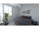 Well-lit bedroom features a window, ceiling fan, bed with gray bedding, and framed prints at 673 Soul Aly # 146, Alpharetta, GA 30009