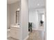 Hallway with wood floors leading to bathroom with white vanity and indoor plants at 673 Soul Aly # 146, Alpharetta, GA 30009