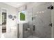 Modern bathroom with a glass enclosed shower, soaking tub, and marble patterned tile walls at 3548 Cedarvale Ct, Powder Springs, GA 30127