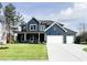Beautiful two-story home featuring a dark blue exterior with a well-manicured lawn and two-car garage at 3548 Cedarvale Ct, Powder Springs, GA 30127