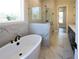 The main bathroom features marble tile throughout, a stand-alone tub and a glass enclosed shower at 3548 Cedarvale Ct, Powder Springs, GA 30127