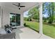 A view of the covered back patio looking out onto a well-maintained lawn and trees at 3548 Cedarvale Ct, Powder Springs, GA 30127