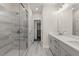 A Primary bathroom features a tiled shower, double sink vanity, and modern lighting fixtures at 656 Soul Aly # 101, Alpharetta, GA 30009