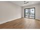 Well-lit bedroom featuring hardwood floors, a ceiling fan, and a sliding glass door at 656 Soul Aly # 101, Alpharetta, GA 30009
