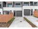 Driveway with well manicured landscaping, leading to modern townhouse garages and entrances at 656 Soul Aly # 101, Alpharetta, GA 30009