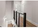 An upstairs hallway features hardwood floors, white walls, and a modern railing with black accents at 656 Soul Aly # 101, Alpharetta, GA 30009
