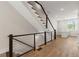 Hallway with modern staircase, hardwood floors, and view of kitchen at 656 Soul Aly # 101, Alpharetta, GA 30009