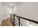 Upstairs hallway featuring a modern railing with black accents, hardwood floors, and neutral-colored walls at 656 Soul Aly # 101, Alpharetta, GA 30009