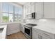 A modern kitchen features white cabinets, stainless steel appliances, and a bright window for natural light at 656 Soul Aly # 101, Alpharetta, GA 30009