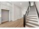 Bright kitchen features white cabinets, a built-in refrigerator, and hardwood floors leading to a staircase at 656 Soul Aly # 101, Alpharetta, GA 30009