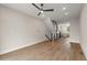 Open-concept living room boasts hardwood floors, a modern ceiling fan, and stairs to the upper level at 656 Soul Aly # 101, Alpharetta, GA 30009