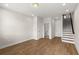 Open-concept living room with hardwood floors, neutral walls, staircase, and natural light at 656 Soul Aly # 101, Alpharetta, GA 30009