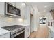 Bright kitchen with stainless appliances, white cabinets, and hardwood flooring, with an open concept design at 656 Soul Aly # 101, Alpharetta, GA 30009