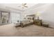 Spacious bedroom featuring a tray ceiling, carpet flooring, and a large decorative mirror at 7678 Gray Pointe Dr, Lithonia, GA 30058