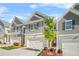 Attractive exterior showcasing a townhouse with a two-car garage and manicured landscaping at 7678 Gray Pointe Dr, Lithonia, GA 30058