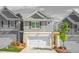Charming townhome showcases a well-manicured lawn, a two-car garage, and beautiful landscaping at 7678 Gray Pointe Dr, Lithonia, GA 30058