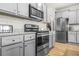 A contemporary kitchen features stainless steel appliances, grey cabinets, and a granite countertop at 7678 Gray Pointe Dr, Lithonia, GA 30058