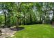 Expansive backyard showcasing a lush lawn, mature trees, and a cozy fire pit area for outdoor entertaining at 2171 Plantation Ln, Chamblee, GA 30341