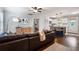 Open-concept living space featuring a large brown leather couch, wood floors, and bar-stool seating to the kitchen island at 2171 Plantation Ln, Chamblee, GA 30341