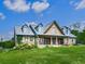 Charming brick two-story home with dormer windows, cedar shake accents, a covered porch, and a lush front lawn at 2347 Univeter Rd, Canton, GA 30115