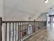 Hallway with hardwood floors and decorative wrought iron railings overlooking stone fireplace at 2347 Univeter Rd, Canton, GA 30115