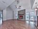 Spacious living room with vaulted ceilings, a stone fireplace, hardwood floors, and a connection to the kitchen at 2347 Univeter Rd, Canton, GA 30115