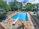Inviting backyard pool with diving board, stone patio, and outdoor fireplace offers the ultimate in outdoor living at 2347 Univeter Rd, Canton, GA 30115