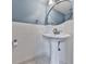A stylish powder room with pedestal sink, white fixtures, and blue accent walls at 2347 Univeter Rd, Canton, GA 30115