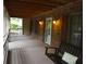 The covered front porch featuring brick walls, a wooden ceiling, and a porch swing at 553 Old Mill Ct, Norcross, GA 30093