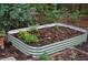 Close up of raised garden bed filled with soil and small blooming flowers at 553 Old Mill Ct, Norcross, GA 30093